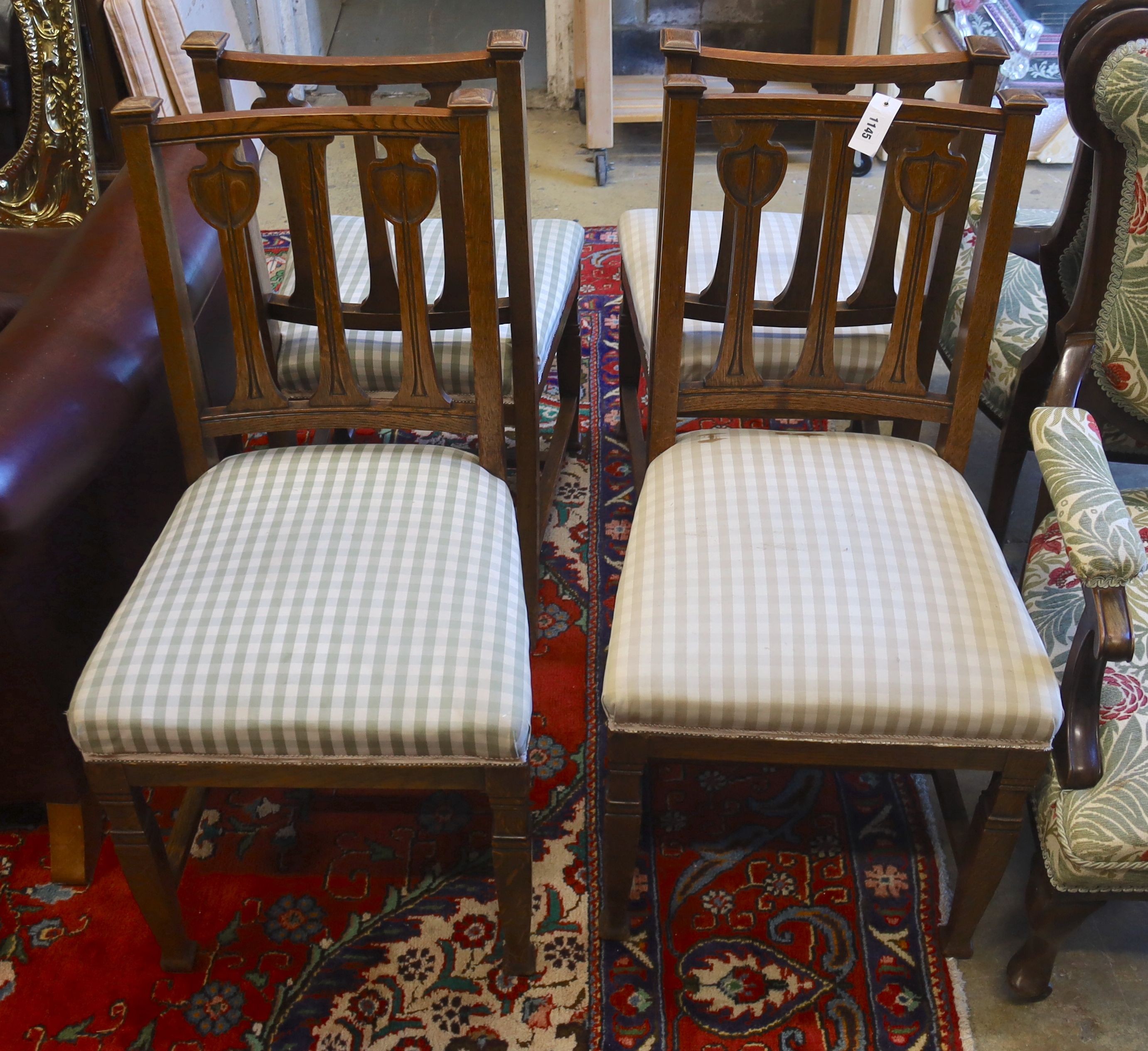 A set of four Art Nouveau carved oak dining chairs